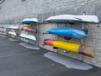 Multiple wall-mounted storage racks for a kayak rental business