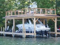 Boathouse with sundeck and boatlift on a permanent pile dock