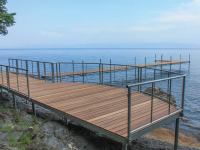 Curved shoreside platform with stainless steel cable rails