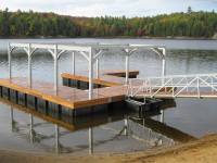 Floating dock designed to support steel frame boathouse