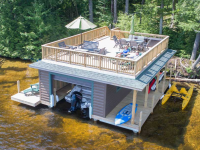 Boathouse with pile dock foundation and sundeck style roof