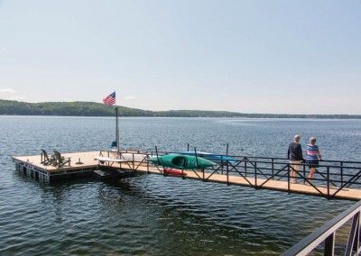 Steel truss floating dock with powder coated railings on gangway and built-in kayak storage