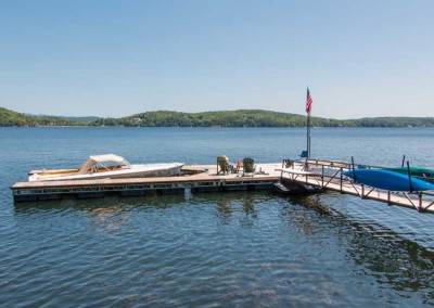 U-shaped galvanized steel truss floating dock with powder coated railings on gangway and built-in kayak storage.