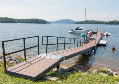 Galvanized steel truss floating dock with spud pole anchoring, powder coated railings on ramp & lower access platform for kayaks.