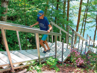 Lightweight aluminum stairs for waterfront access on a steep, sloped site. Includes 3' x 4' platform for this long run of stairs