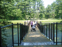 Floating golf cart bridge with black powder coated railings at a municipal golf course